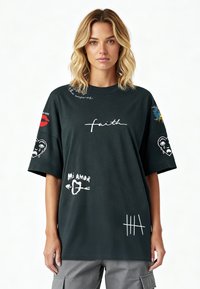 Liels melns kokvilnas T-kreklis ar dažādām grafiskām darnām, tostarp tekstiem un ilustrācijām baltā, sarkanā un zilā krāsā. Īsas piedurknes.