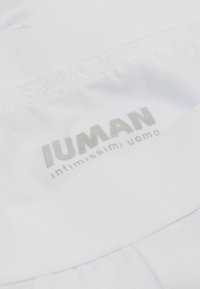 Weiße Baumwoll-Boxershorts für Herren mit einem weichen elastischen Bund, auf dem graue Schriftzüge "IUMAN intimissimi uomo" stehen. Glatte Textur.