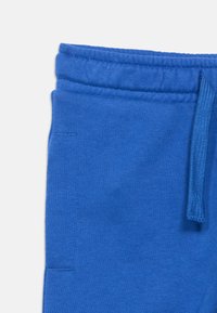 Μπλε φόρμα με μαλακή υφή, ελαστική μέση και ρυθμιζόμενο κορδόνι. Διαθέτει πλευρικές τσέπες και μίνιμαλ σχεδιασμό.