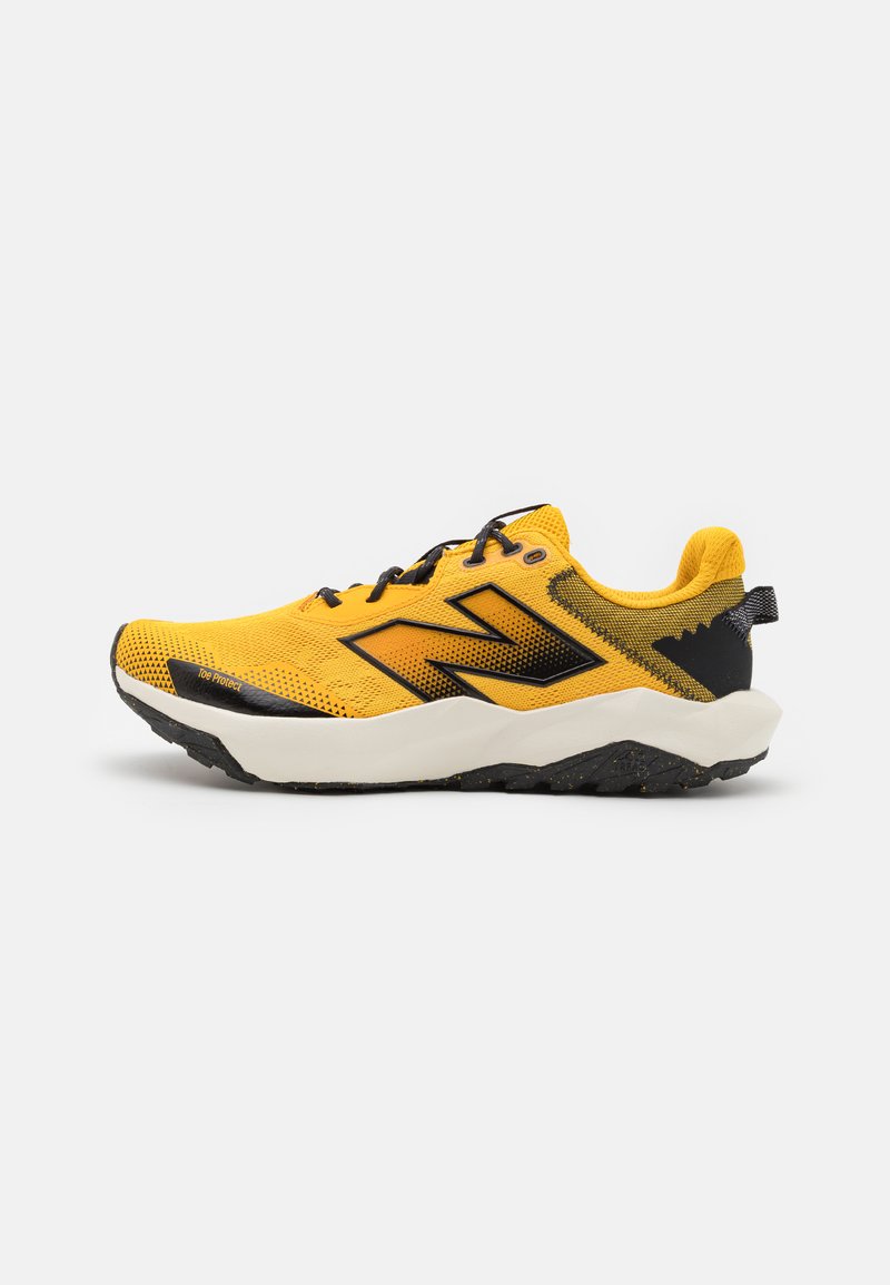Yellow athletic shoe with mesh upper, black accents, padded collar, and rugged sole. Features prominent brand logo on the side.