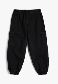 Svarta denim cargobyxor med elastisk midja, smalnande benmuddar och sidofickor. Har en slät textur och praktiska designinslag.