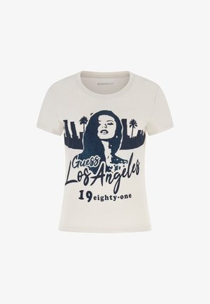 Kreemikreemist t-särk lühikeste varrukatega, millel on mereväe sinine graafika naise siluetist, tekst "Guess Los Angeles" ja "1981."