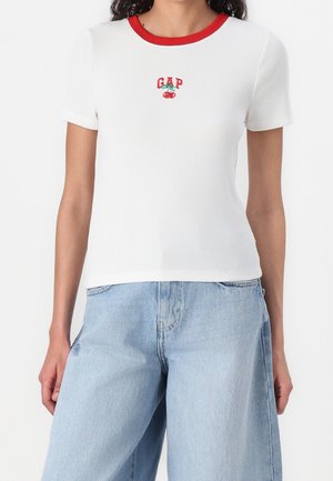 Biała prążkowana koszulka z krótkim rękawem z czerwoną obwódką przy kołnierzyku i małym motywem wiśni z napisem "GAP" nad wzorem.