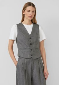 Grijs pinstriped gilet met een aansluitend ontwerp, voorzien van een V-hals, vier zwarte knopen en zijzakken, gecombineerd met een wit T-shirt.