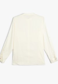 Camicia a maniche lunghe color crema con una texture liscia, colletto arrotondato e polsini con bottoni. Presenta una vestibilità comoda e un orlo dritto.