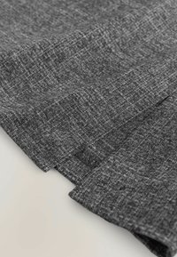 Material gri cu o textură țesută, având margini pliate. Suprafața are un model subtil și un ușor luciu, indicând un material moale.