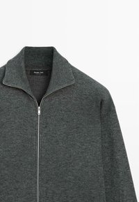 Maglione zip grigio scuro con colletto alto, realizzato in tessuto testurizzato. Presenta una cerniera argentata e un'etichetta con la scritta "Massimo Dutti."