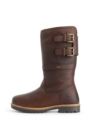 Botte mi-mollet en cuir marron avec deux sangles réglables à boucle, surface texturée et semelle à relief, vue de côté sur fond blanc.