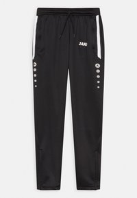 Schwarze Sporthosen mit einem Kordelzugbund, seitlichen Taschen, weißen Akzenten und grauen runden Details entlang der äußeren Beine. Mit "JAKO"-Logo.