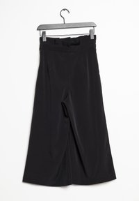 Czarne spodnie o szerokich nogawkach z gładką teksturą, wysokim stanem i zakładkami, wiszące na czarnym metalowym wieszaku na białym tle.