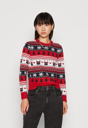 Pull rouge et marine avec motifs de Noël, incluant des rennes, des arbres, des flocons de neige et des cœurs, avec des poignets et un ourlet côtelés.