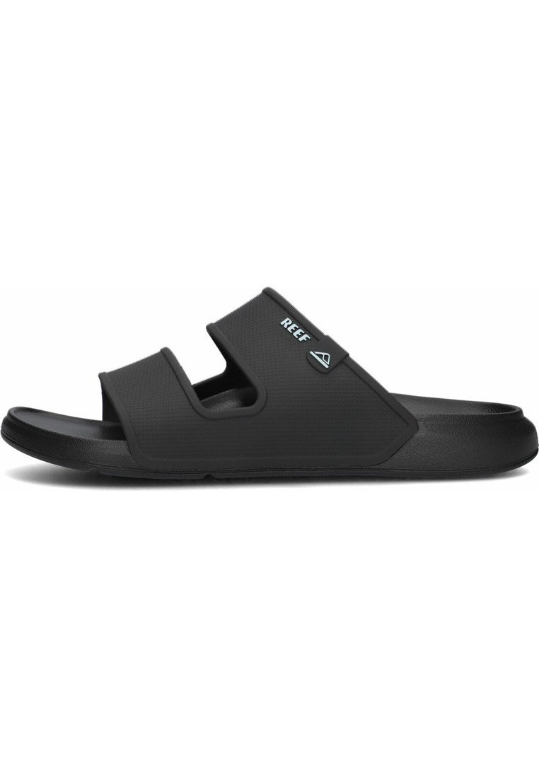 Zwarte slipper met een textuur bovenkant, een verstelbare band en een logo-accent. Duurzame rubberen zool ontworpen voor comfort en grip.