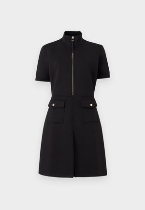 Črna obleka s kratkimi rokavi, z visokim ovratnikom, sprednjo zadrgo in dvema poklopnima žepoma z zlatimi gumbi na pasu, krilo v obliki črke A.