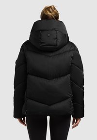 Schwarze Steppjacke mit hohem Kragen, Chevron-Steppmuster und Knopfakzent auf der Rückseite. Verfügt über lange Ärmel und eine lockere Passform.
