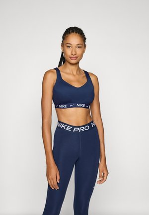 Navy sports bra and leggings set by Nike. Bra features a v-neck and wide straps. Leggings have a branded elastic waistband with a smooth texture.