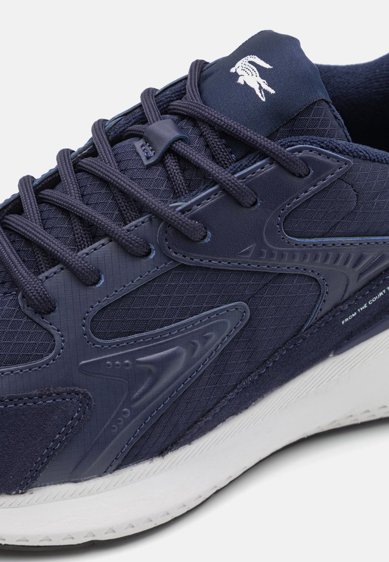 Marineblauwe sportschoen met een gemêleerde mesh bovenkant, gevoerde tong en veters. Heeft een wit logo en een duurzame rubberen zool.