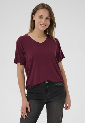 Burgundy V-neck t-shirt with short sleeves, soft fabric, loose fit, worn over black jeans, minimalistic design with no visible patterns or accents.