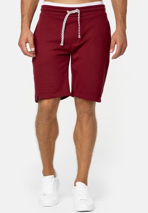 Bordeaux træningsshorts med elastisk talje og en hvid snor. Lavet af et blødt, glat materiale; har sidelommer og en afslappet pasform.
