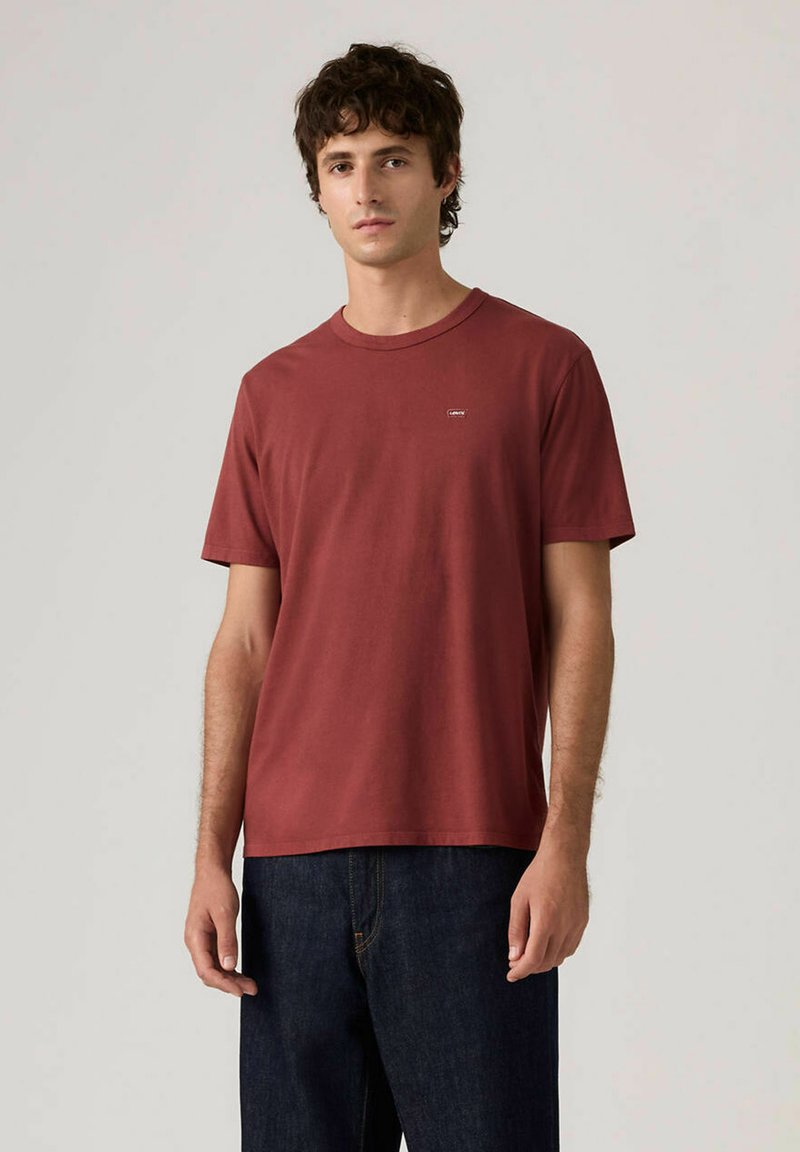 T-shirt manches courtes bordeaux en coton, avec un col rond et un petit logo sur la poitrine. Coupe standard et texture lisse.