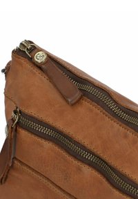 Braune Ledertasche mit mehreren bronzefarbenen Reißverschlussfächern und einer strukturierten Oberfläche. Verfügt über ein genähtes Design und ein kleines Logo-Detail.