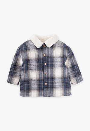 Zilā, baltā un pelēkā krāsā raibu krekla jaka ar mīkstu balto apkakli. Iekļauj koka pogas un īsas piedurknes. Tekstūrēts, silts audums.