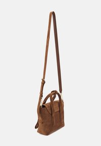 Brun corduroy taske med en struktureret form, dobbelt topremme og en aftagelig justerbar skulderrem. Hardware i guldtoner som accent.