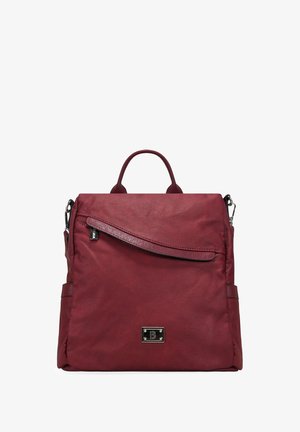 Mochila burdeos hecha de cuero texturizado, con un bolsillo frontal con cremallera, asa superior y correas de hombro ajustables. Detalle del logo en metal.