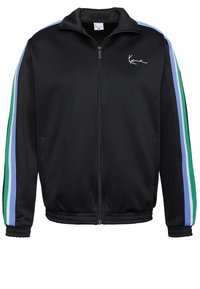 Juodas zip-up švarkas su stovinčia apykakle, puikiai derantis su mėlynomis, žaliomis ir šviesiai mėlynomis juostelėmis ant rankovių. Lygus audinys su elastinėmis rankogaliais.