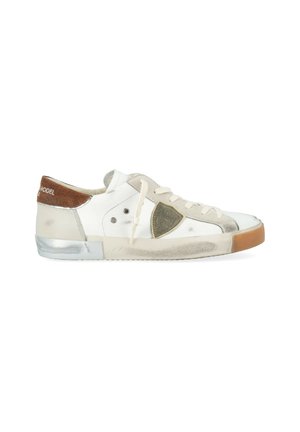 Sneaker bassa bianca con lacci beige, linguetta in suede marrone, suola in gomma usurata con segni di usura e un emblema a scudo sul lato.