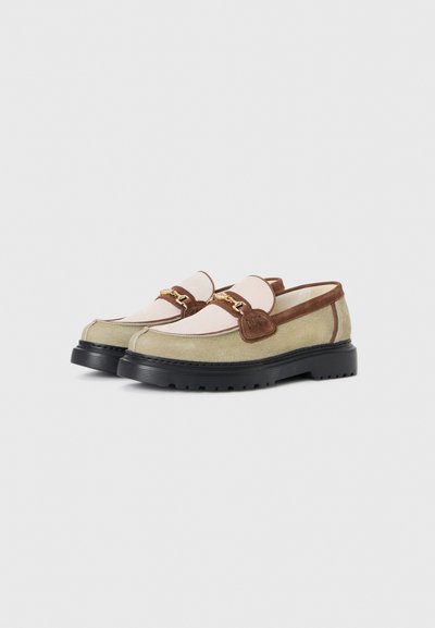 Loafers med en grøn ruskindsoverdel, pink stofpanel, brune detaljer og sort gummisål. Har detaljer i guld på stropperne.