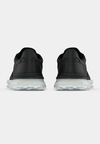 Μαύρα αθλητικά παπούτσια με λείο επάνω μέρος, επενδεδυμένο κολάρο και διαφανή σόλα. Διαθέτουν υφασμάτινες λεπτομέρειες και ενισχυμένη φτέρνα.