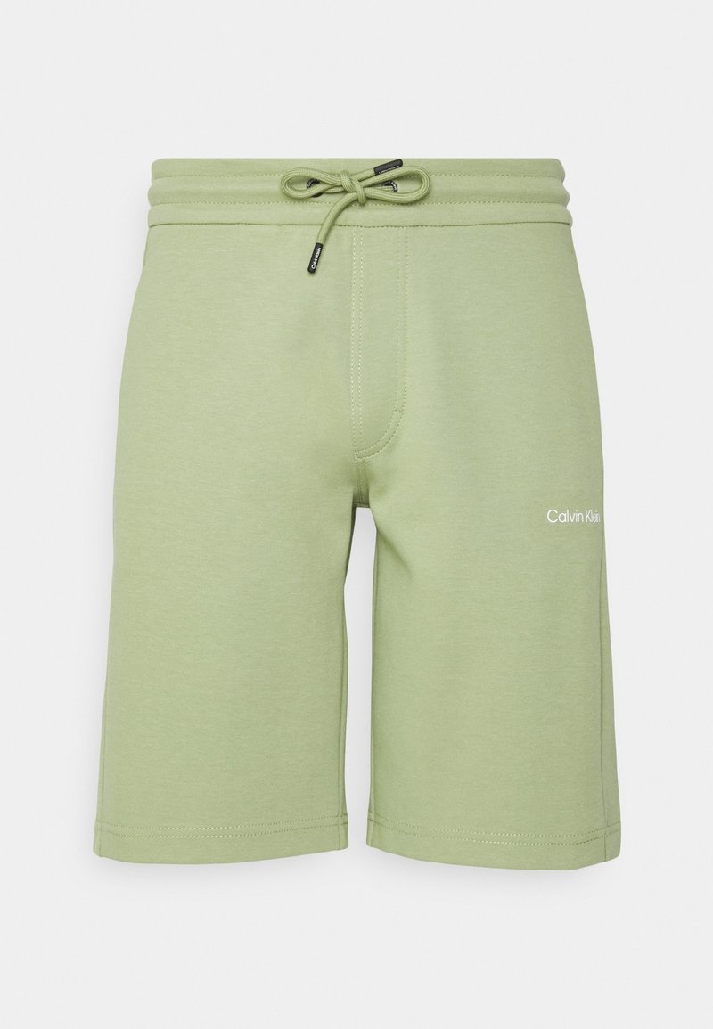 Light green cotton shorts with an elastic waistband, drawstring, and logo detail on the left leg. Smooth texture and knee-length cut.