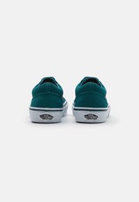 Teal suede low-top sneakers with white rubber soles, featuring a green stripe and Vans "Off the Wall" logo on the heel tab.