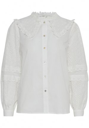 Vit blus med ett volangkrage, knappfront och broderad ögla-detalj på puffärmar. Har en subtil lyster och mjuk textur.