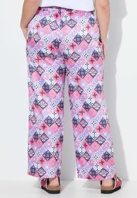 Gemusterte weit geschnittene Hose mit einem bunten geometrischen Design in Pink, Lila und Weiß, aus leichtem Stoff mit einem elastischen Bund.