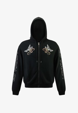 Musta vetoketjuhuppari, joka on valmistettu puuvillasta. Siinä on brodeeratut siipi- ja käärmeaiheiset suunnittelut rinnan kohdalla. "ED HARDY" -logo on painettu hihan päälle.