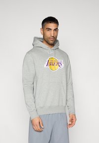 Sweat à capuche gris avec une poche kangourou à l'avant. Présente un logo coloré "Los Angeles Lakers" avec un graphique de ballon de basket jaune.