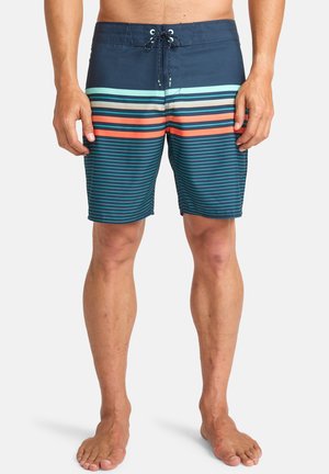 Costumi da bagno da uomo con base blu, decorati con strisce orizzontali in acqua, corallo e blu navy. Vita con cordoncino e design fino al ginocchio.