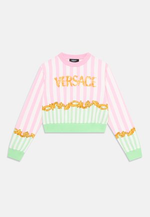 Raidallinen lyhyt neulepaita vaaleanpunaisena ja vihreänä kullanvärisellä "Versace"-logolla sekä koristeellisella kukkakuviolla helmassa ja hihoissa. Pehmeä kangas.