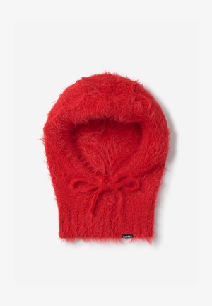 Pasamontañas de punto peludo rojo con un pequeño lazo en el cuello y una etiqueta negra visible en el borde inferior.