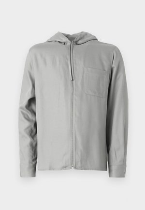 Hanorac cu fermoar de culoare gri deschis, cu mâneci lungi, buzunar frontal și glugă căptușită. Textură netedă cu un design simplu și fără modele vizibile.