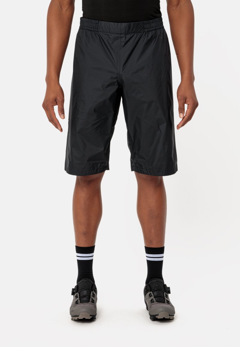 Pantaloni corti neri, leggeri, con una cintura elastica, taglio fino al ginocchio e una texture liscia, abbinati a calze nere con strisce bianche.