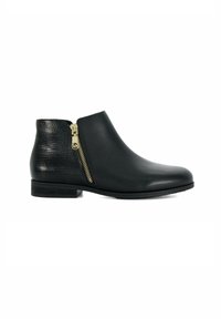 Bottine en cuir noir avec talon texturé, fermeture éclair latérale dorée et petit talon empilé sur fond blanc.