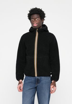 Schwarze Fleecejacke mit Kapuze, ausgestattet mit einem bunten, gestreiften Reißverschluss. Der Stoff ist weich und strukturiert, mit gerippten Bündchen und Saum.