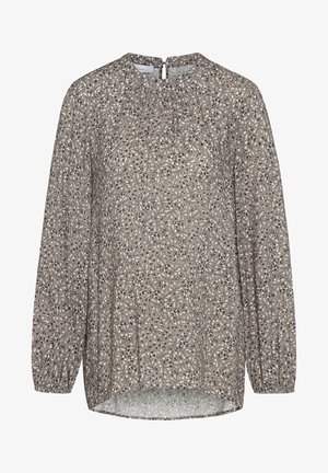 Blusa a maniche lunghe color beige con stampa floreale nera. Caratterizzata da un colletto rotondo, dettagli arricciati e un orlo posteriore leggermente allungato.