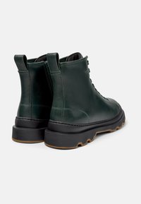 Grønne lær ankle boots med sorte gummisåler, der har snørebåndsdesign og huller til nem påtagning. Velegnet til forskellige forhold.