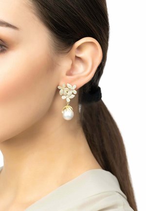 Goldene Blumenohringe mit klaren Kristallakzenten und einer großen Perle als Anhänger. Diese Ohrringe zeichnen sich durch filigrane Blätterdesigns und eine glänzende Oberfläche aus.