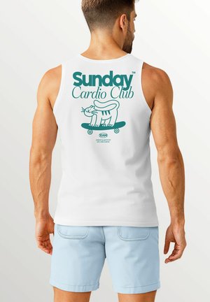 White tank top featuring a turquoise graphic of a cat on a skateboard with “Sunday Cardio Club” text above. Cotton material, relaxed fit.