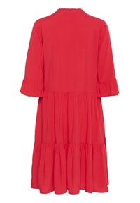 Robe rouge en tissu léger, avec un col et des manches volantés, et une jupe à volants.