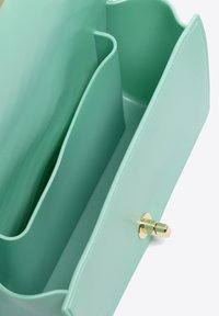 Borsa in ecopelle verde menta con un design strutturato, dotata di due scomparti interni e chiusura con bottone dorato. Texture liscia.